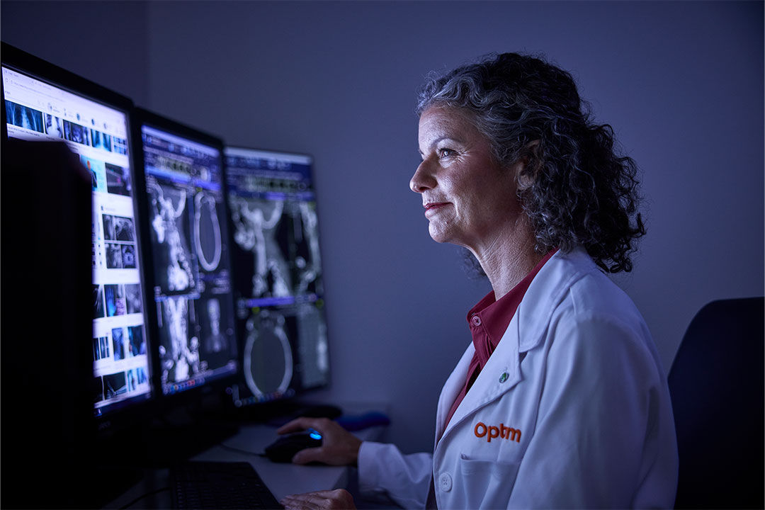 Physician viewing documentation on multiple monitors.